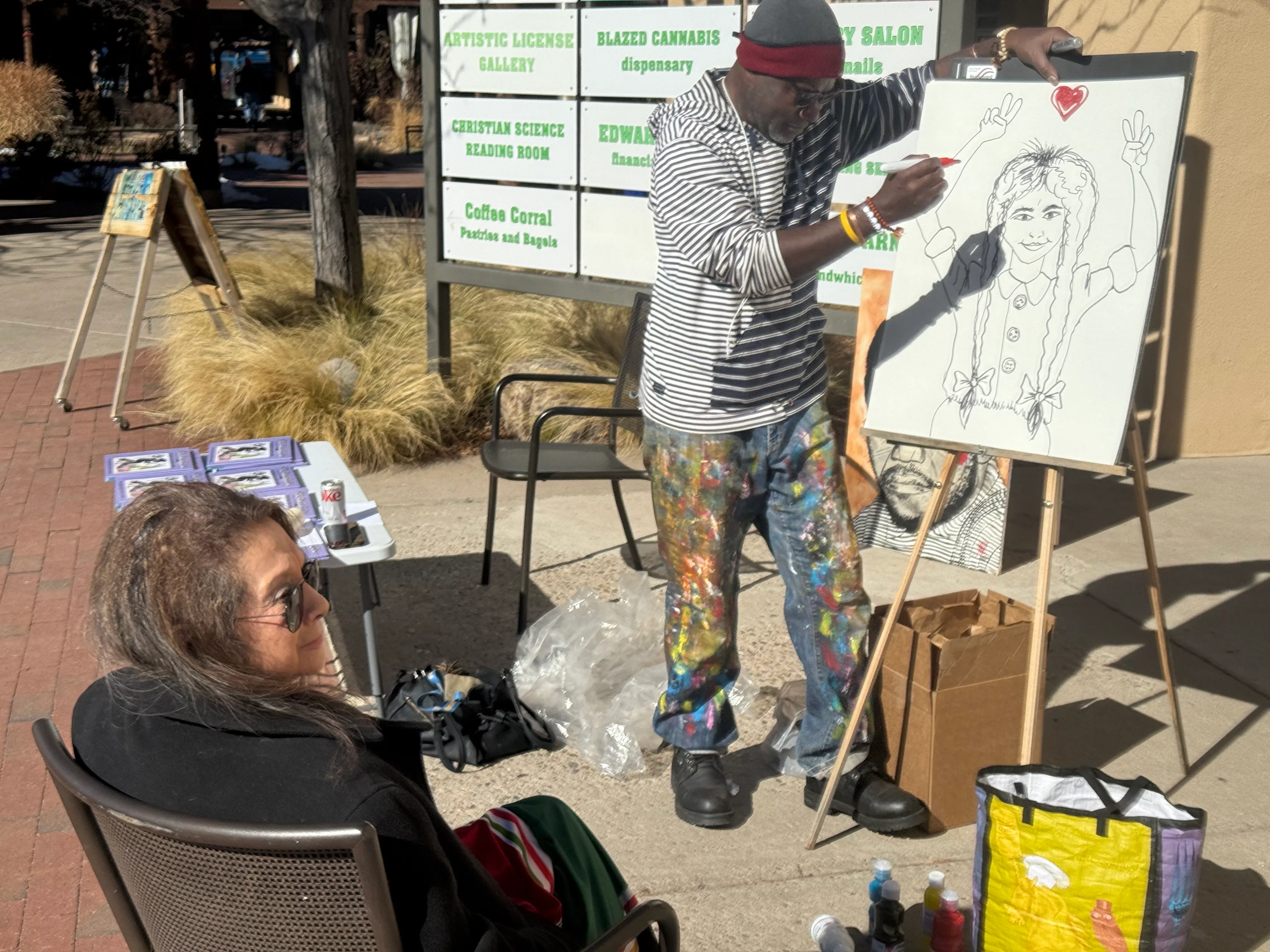 Issa Nyaphaga painting outdoors with Nancy Perez Fugere observing